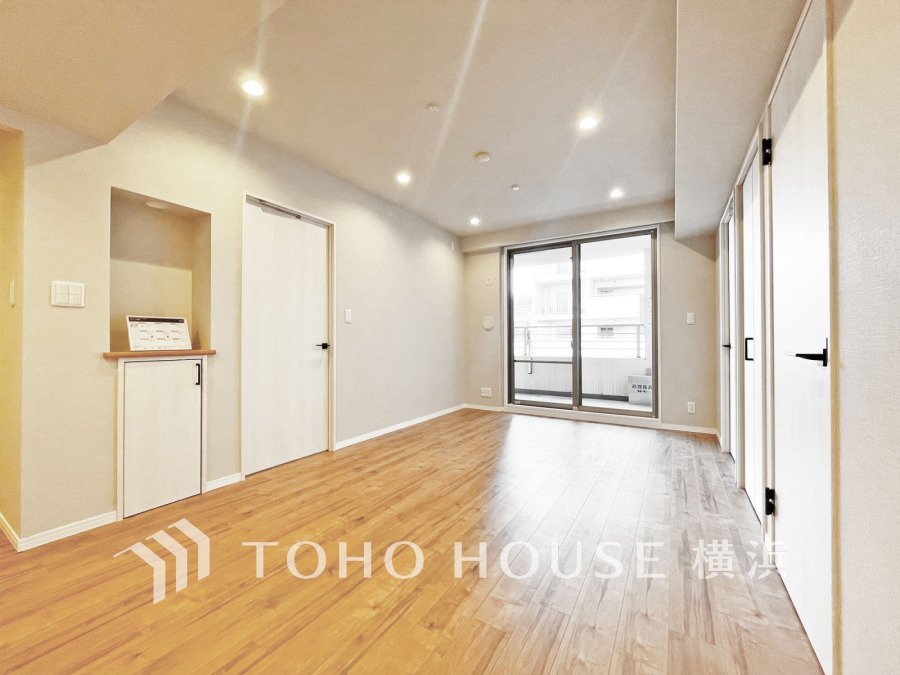 明るい自然光が差し込む広々としたリビング。ナチュラルな木目フローリングで温かみのある空間です。