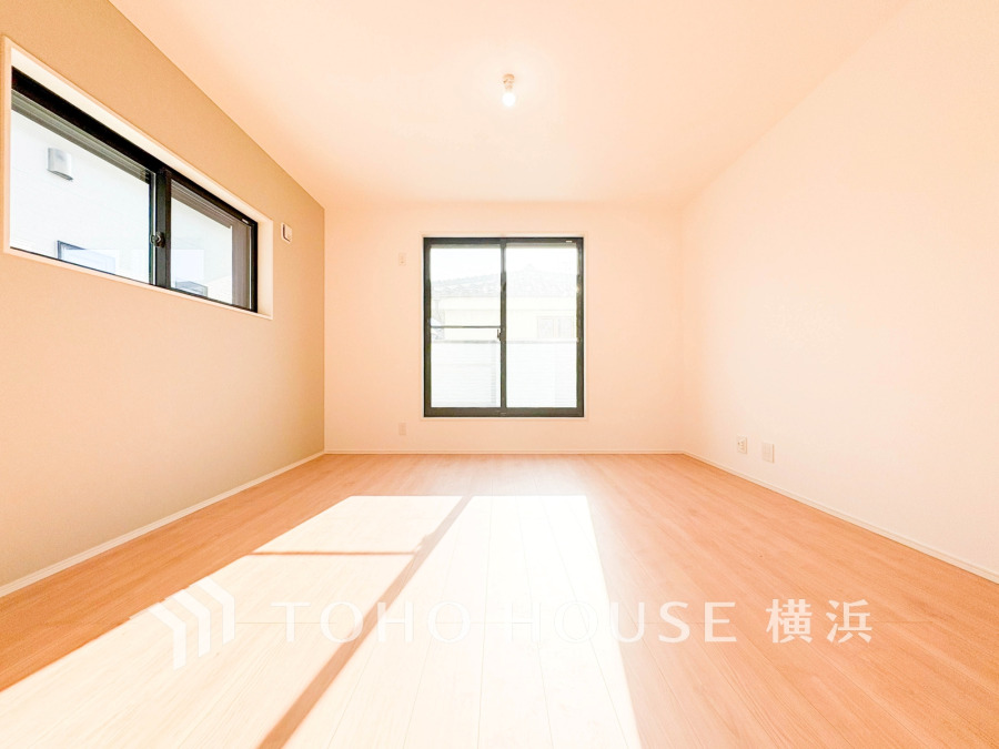 明るい光が差し込むシンプルで開放感のあるリビング。ナチュラルな色合いで落ち着いた空間を演出します。