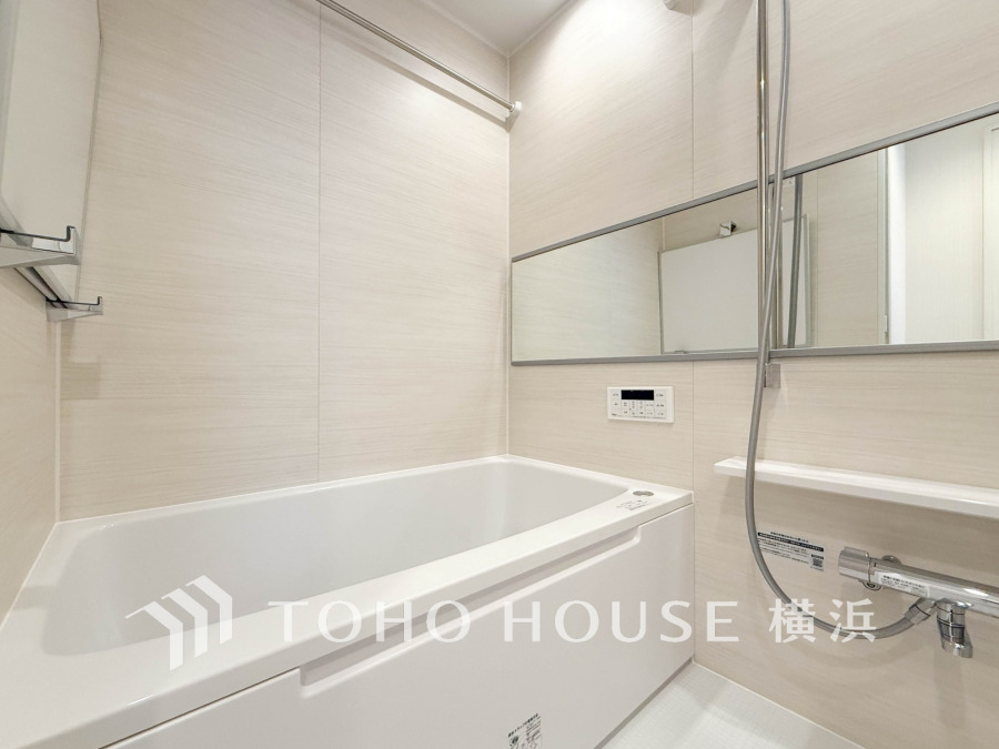 清潔感あふれるホワイト基調のバスルーム。広めの浴槽と壁一面の横長ミラーでゆったり快適な空間を実現しています。