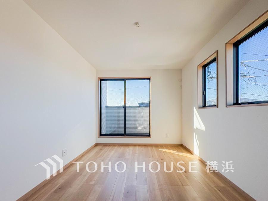 明るい自然光が差し込むシンプルで清潔感のある洋室。バルコニーへも続く開放的な空間です。