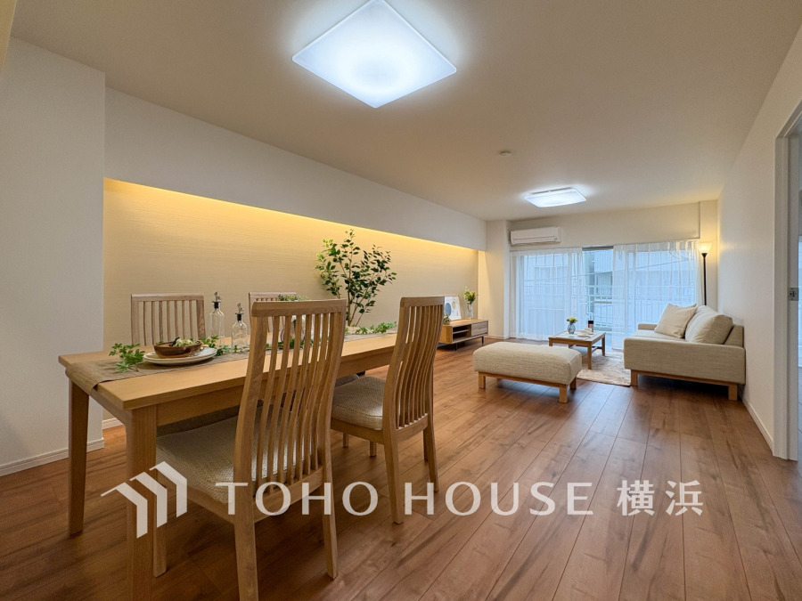 自然光がたっぷり入る開放的なリビングダイニング。木の温もりと間接照明が安らぎを演出します。