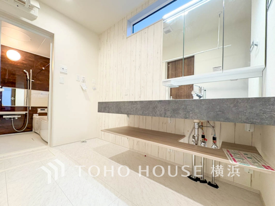 清潔感あふれる洗面スペース。大きな鏡と収納棚が使い勝手の良さを実現しています。バスルームも隣接で便利です。