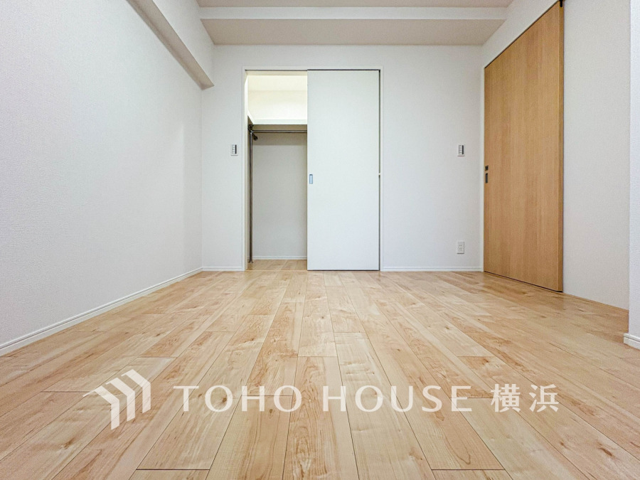 ナチュラルな木目のフローリングとシンプルな白壁が調和した、清潔感あふれる居室空間です。