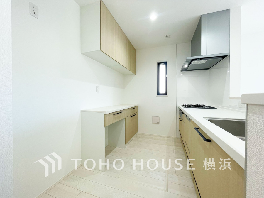 収納棚を背面に設置した統一感のあるキッチンスペースは美しく、機能性も良好です。
