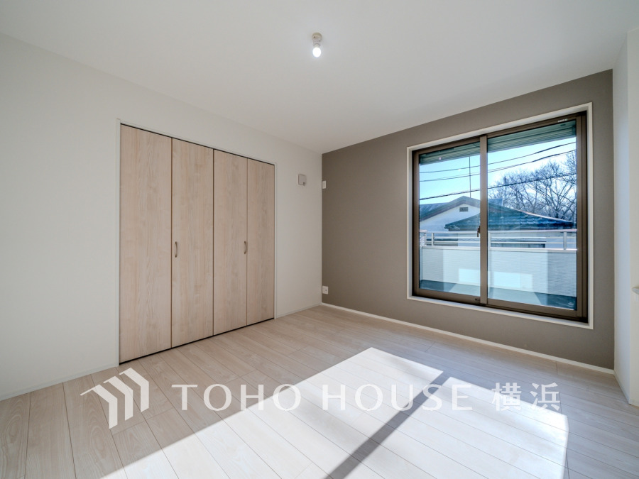 バルコニーから明るい自然光が差し込む洋室。大型クローゼット付きで収納も充実しています。
