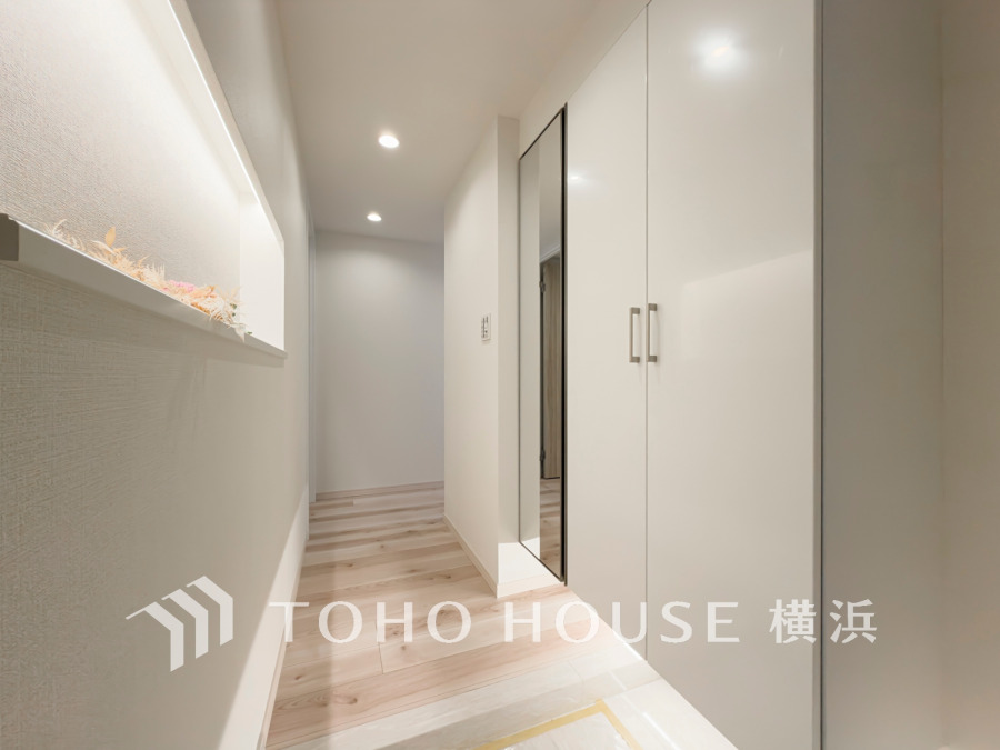 清潔感あふれる白を基調とした玄関ホール。便利なミラー付き収納です。