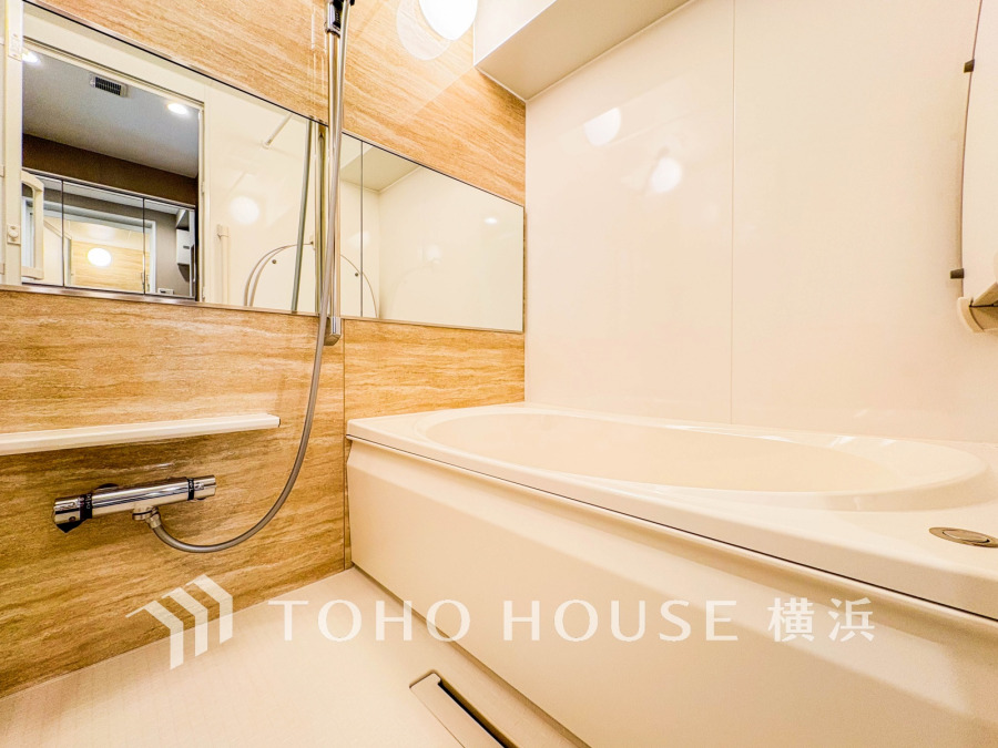 落ち着いた木目調の壁が温かみを演出する、清潔感あふれるゆったりバスルームです。