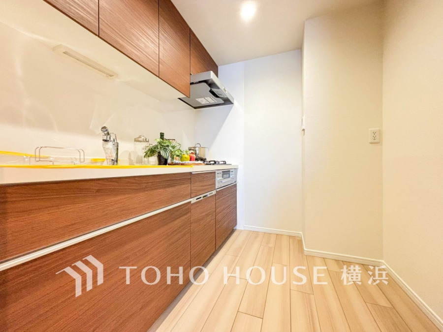 木目調の温かみあるキッチンは収納力豊富で、使いやすさと清潔感を兼ね備えた快適な調理空間です。