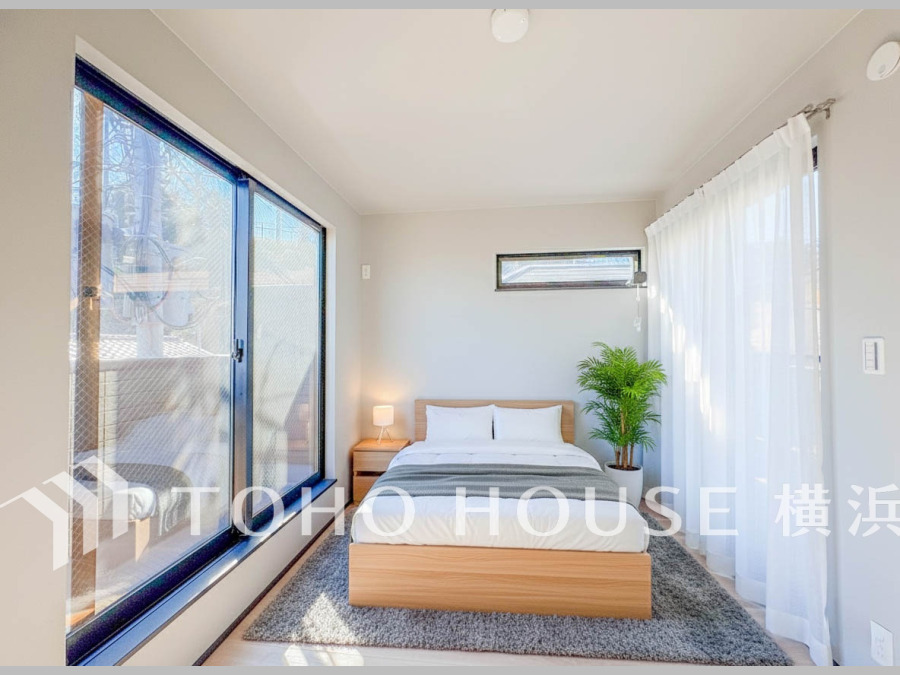 大きな窓から自然光がたっぷり入る明るい寝室。シンプルで落ち着いた空間が心地よい安らぎを提供します。（家具はAI加工です）