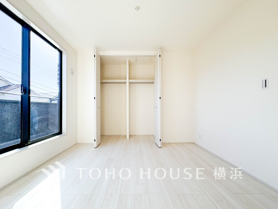 陽光が差し込む明るい洋室。大容量のクローゼット付きで収納力も充実しています。