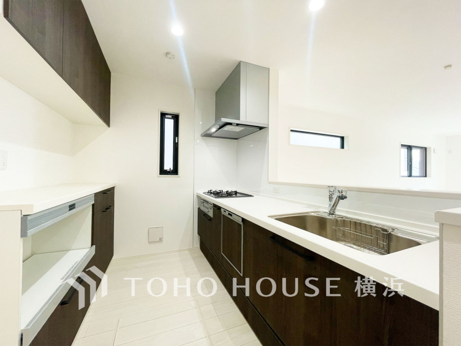 収納棚を背面に設置した統一感のあるキッチンスペースは美しく、機能性も良好です。
