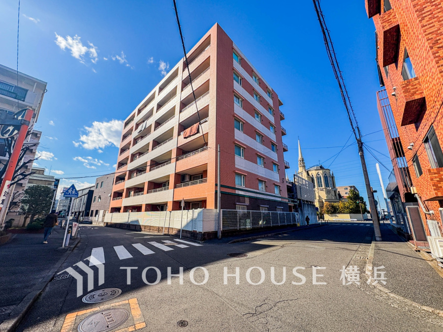 青空に映えるマンションの外観は、明るく開放的な暮らしを予感させます。周辺には歴史ある教会もあり、落ち着いた住環境で家族の時間を育めます。