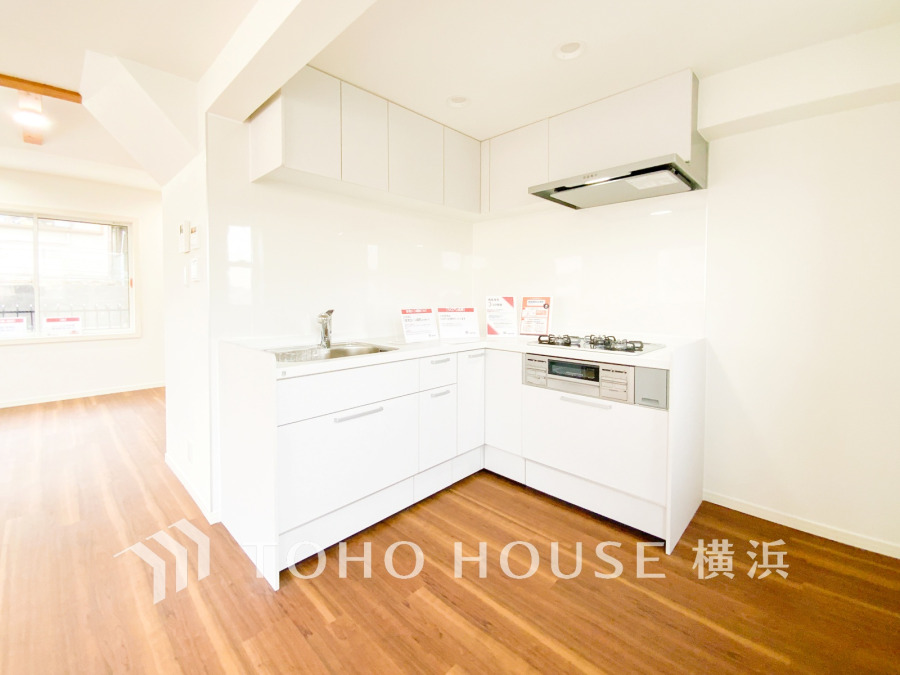 清潔感あふれる白を基調としたL字型キッチン。収納豊富で作業効率の良い快適な調理空間です。