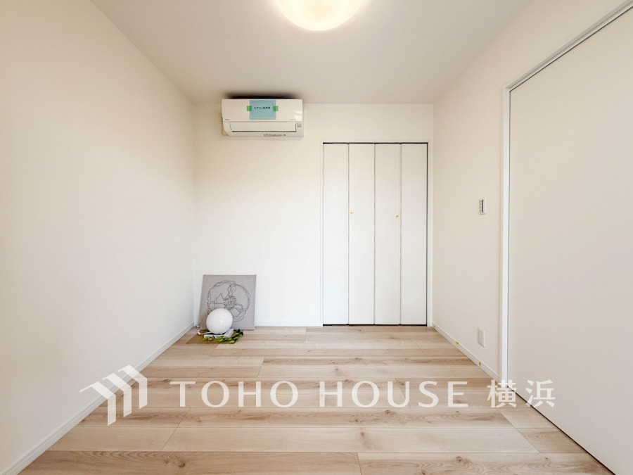 シンプルで明るい空間に大容量クローゼットを備えた洋室。エアコン完備で快適な住まいを実現します。