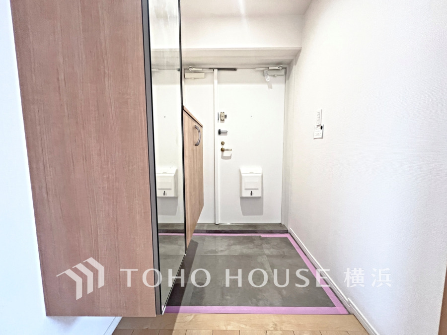 豊富な収納を確保した玄関スペース。便利な大型のミラーのついたシューズボックスを設置。
