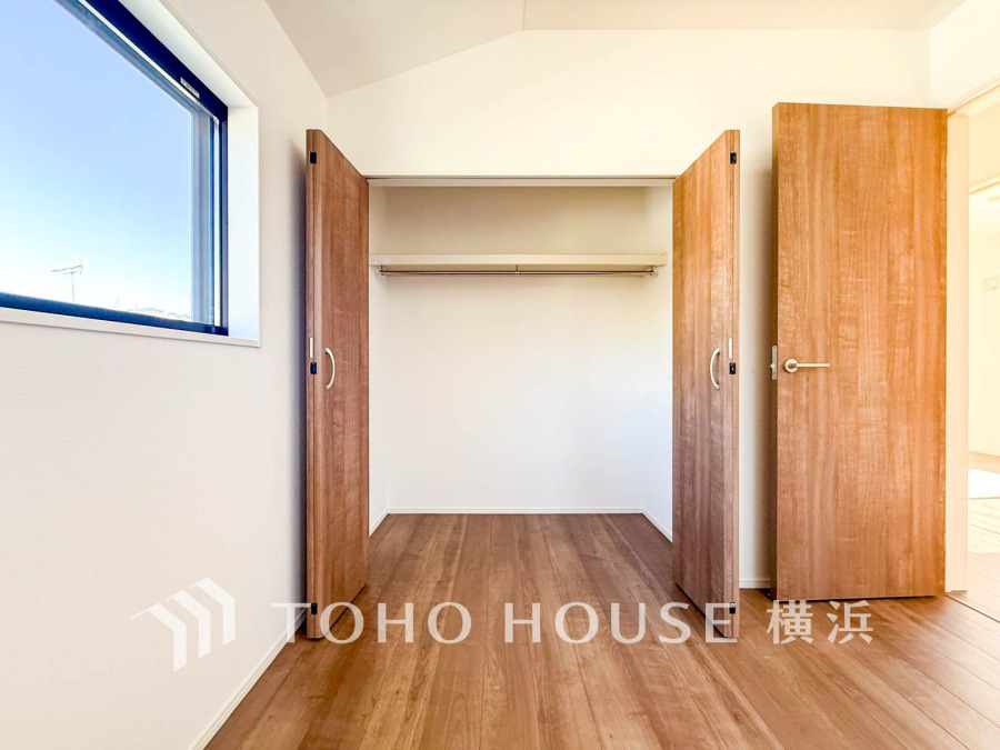 大容量収納可能なクローゼット付きの明るく開放的な洋室。自然光が差し込み、快適な居住空間を演出します。