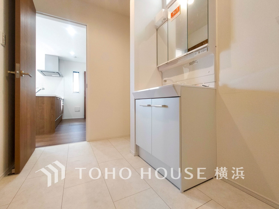 清潔感あふれる洗面スペース。隣接するキッチンへの動線も良く、家事効率を高めます。