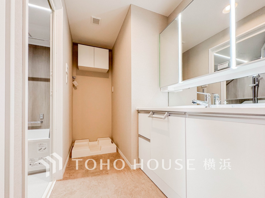 清潔感あふれる洗面室。大きな鏡と収納で使い勝手抜群、隣接する浴室への動線もスムーズです。