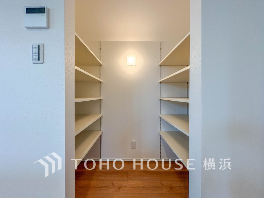 両側に棚が並ぶ大容量のパントリースペース。小物から大きな物まで整理しやすく、使い勝手の良い設計です。