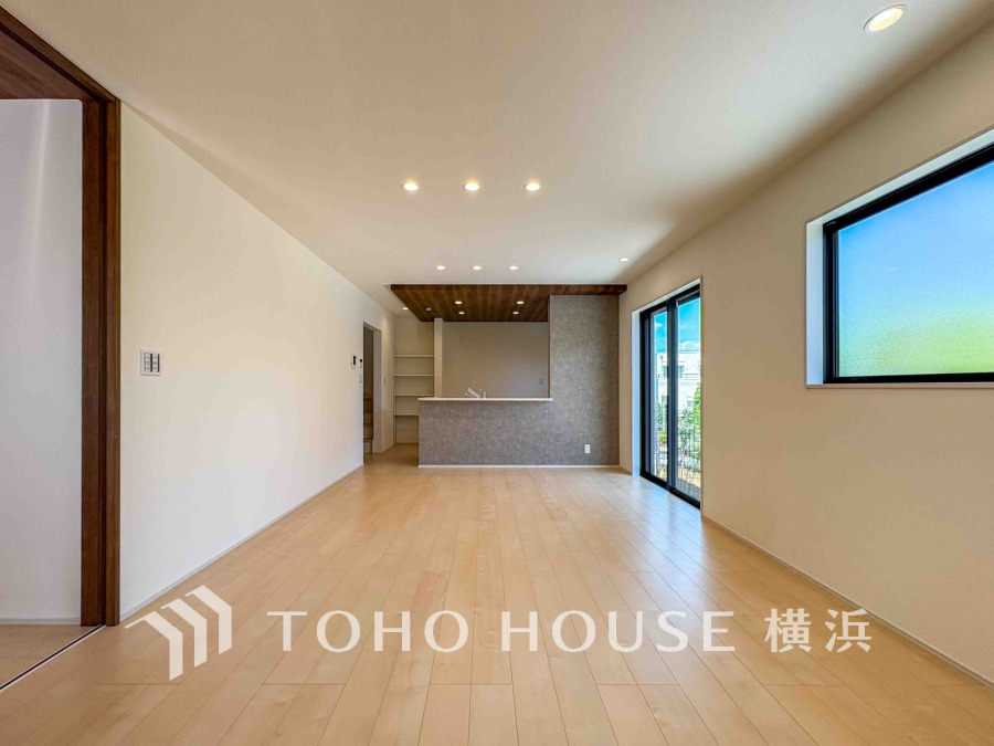 明るい自然光が差し込む広々としたリビング。木目天井がアクセントの対面キッチンで快適な暮らしを実現。