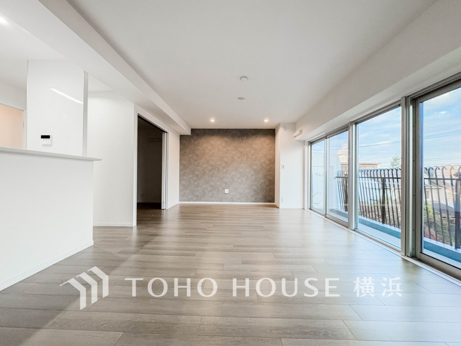 大きな窓から自然光が差し込む、明るく開放的なリビング空間。シンプルで洗練されたデザインが魅力です。