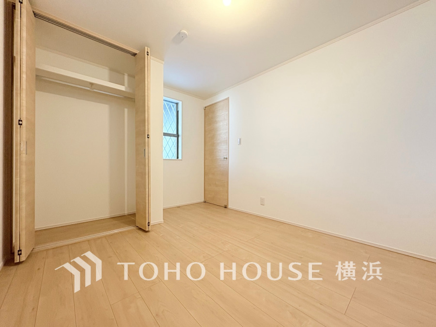 ナチュラルな木目調フローリングと大容量クローゼットを備えた明るく清潔感のある洋室です。