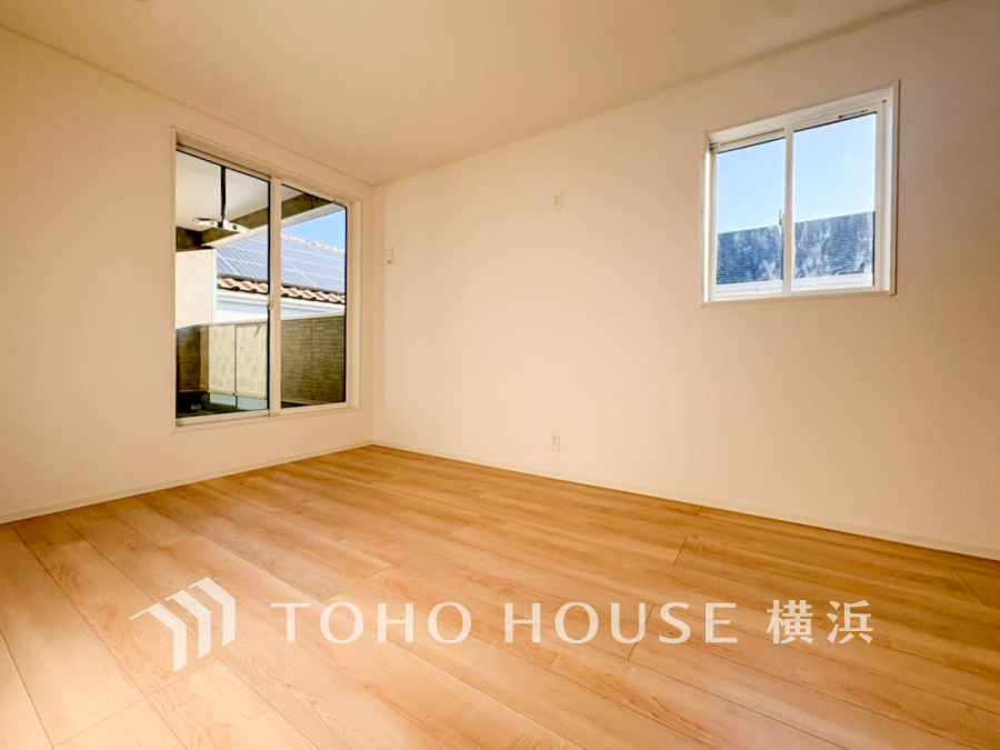 明るい自然光が差し込む、シンプルで清潔感のある洋室。バルコニーに続く大きな窓が魅力です。