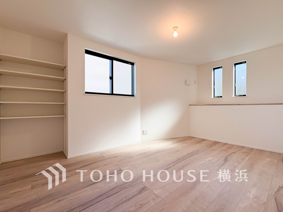 明るい自然光が差し込む、収納棚付きのシンプルで使いやすい洋室です。ゆったりとした空間が魅力。