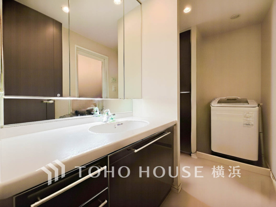 ご家族の1日が始まり、1日の終わりを締めくくる洗面空間。洗濯機を配置しても十分なスペースを確保した設計となっております。（AI加工しています）