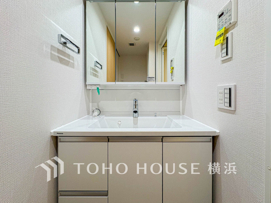 清潔感あふれる白を基調とした洗面台。大きな三面鏡と収納スペースで使い勝手も抜群です。