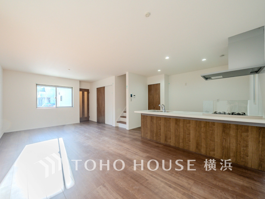 自然光が差し込む広々としたリビング。木目調のキッチンが温かみを演出する快適な空間です。