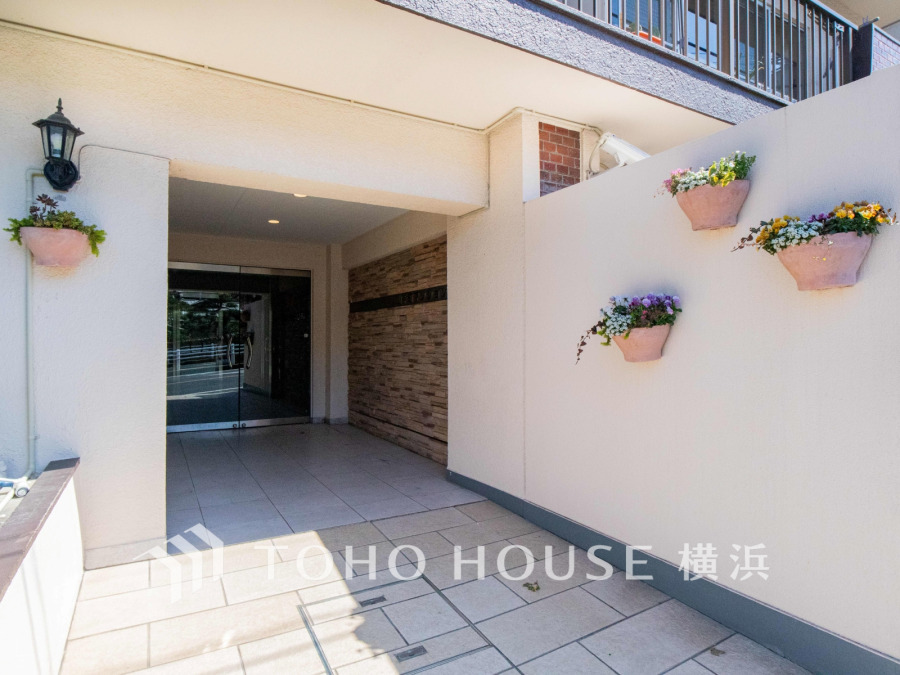 温かみのある花の装飾が彩る、穏やかな暮らしを描くマンションエントランスです。