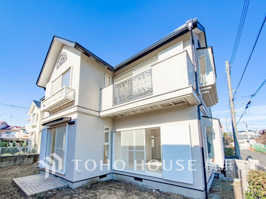 閑静な街並みに調和する落ち着いた外観。ふりそそぐ陽射しと青空を背景に美しさを醸す佇まい。
