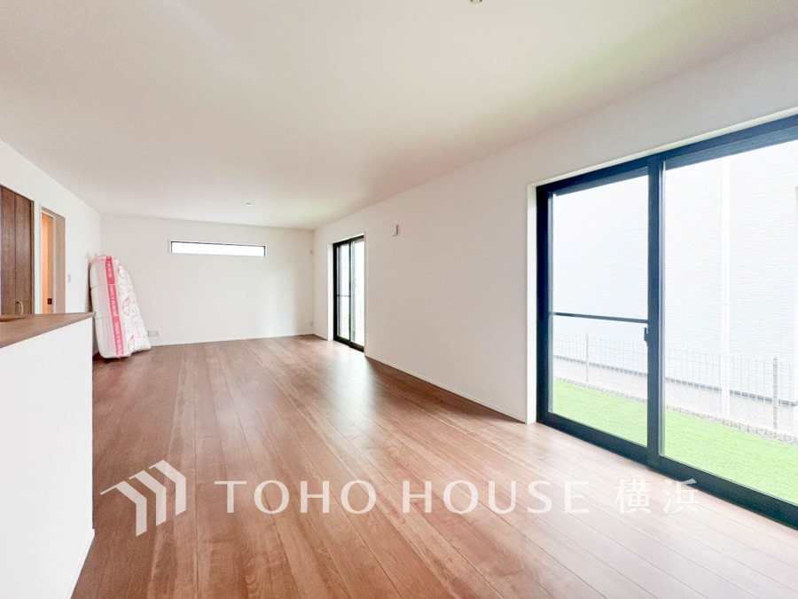 大きな窓から光が差し込む、開放感あふれる広々リビングダイニング。木目調の床が温かみを演出します。