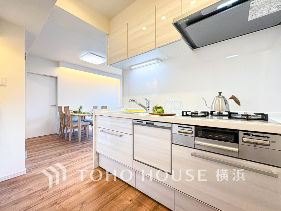 清潔感あふれるシステムキッチンと、木目調の床が温かみを演出する開放的なダイニング空間です。