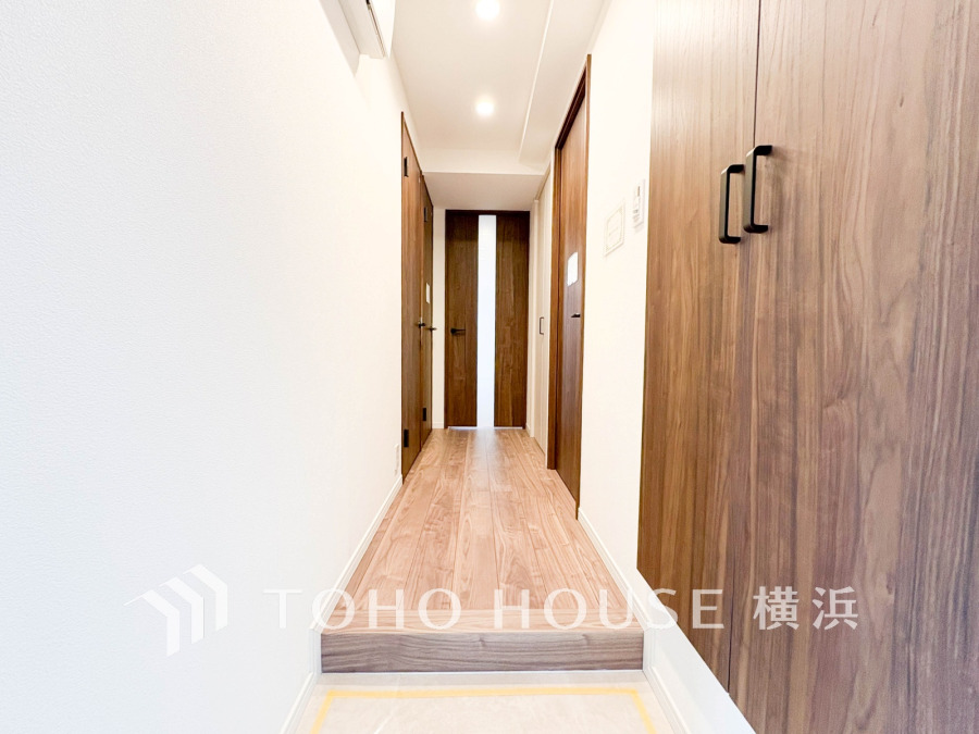 木目調の扉と床が温かみを演出する、明るく清潔感のある玄関ホールです。収納も充実しています。