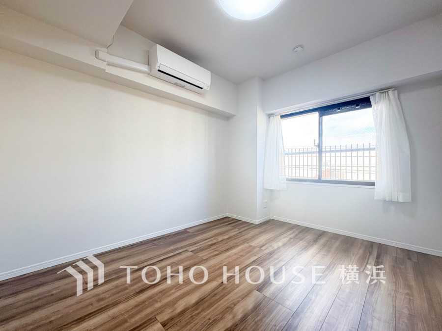 明るい光が差し込む、シンプルで清潔感のある洋室。エアコン完備で快適な空間です。