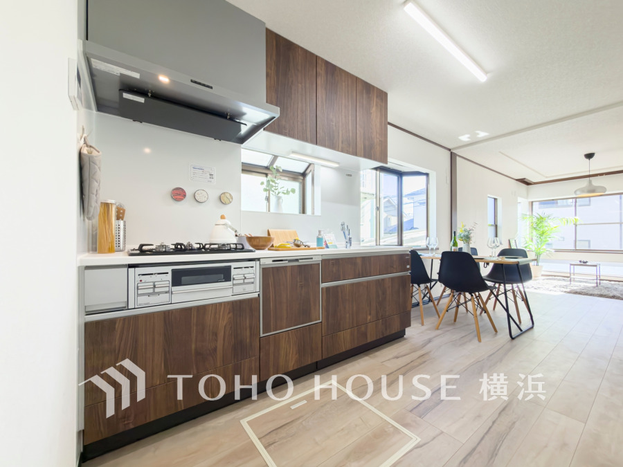 木目調のキッチンと明るいリビングが織りなす、開放感あふれる快適な空間設計です。