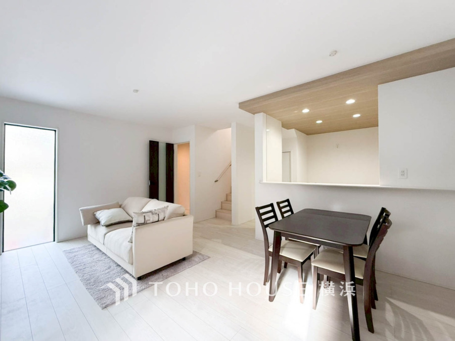 光あふれる白基調のリビングダイニング。木目天井が温かみを演出し、家族のくつろぎ空間を創出します。