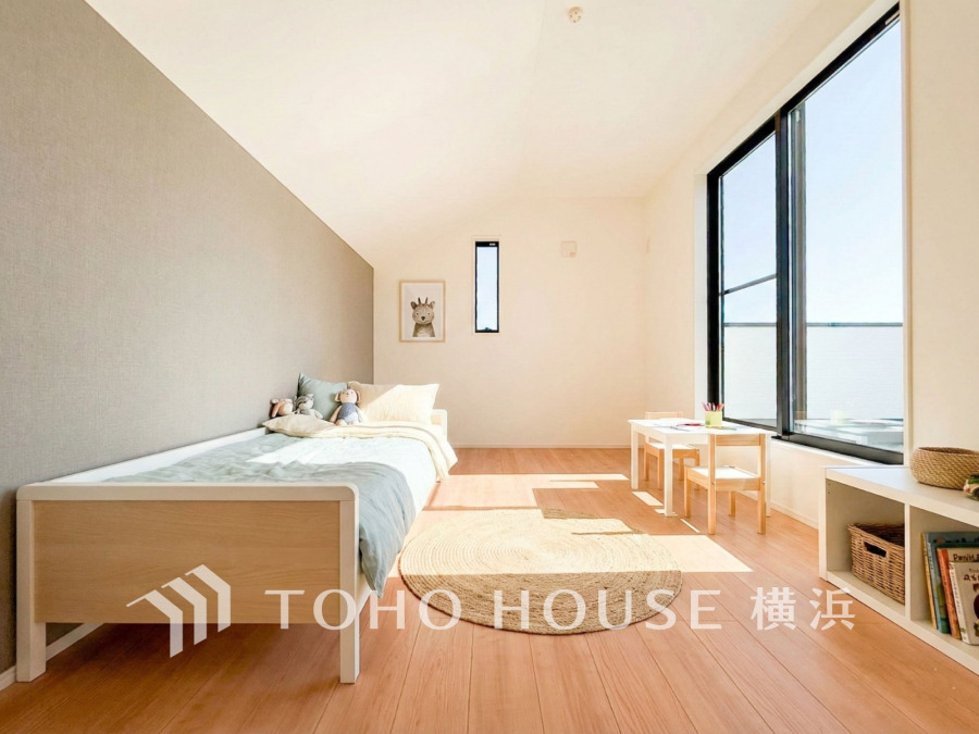 大きな窓から光が差し込む明るい子供部屋。シンプルで温かみのある空間が広がります。（家具はAI加工です）