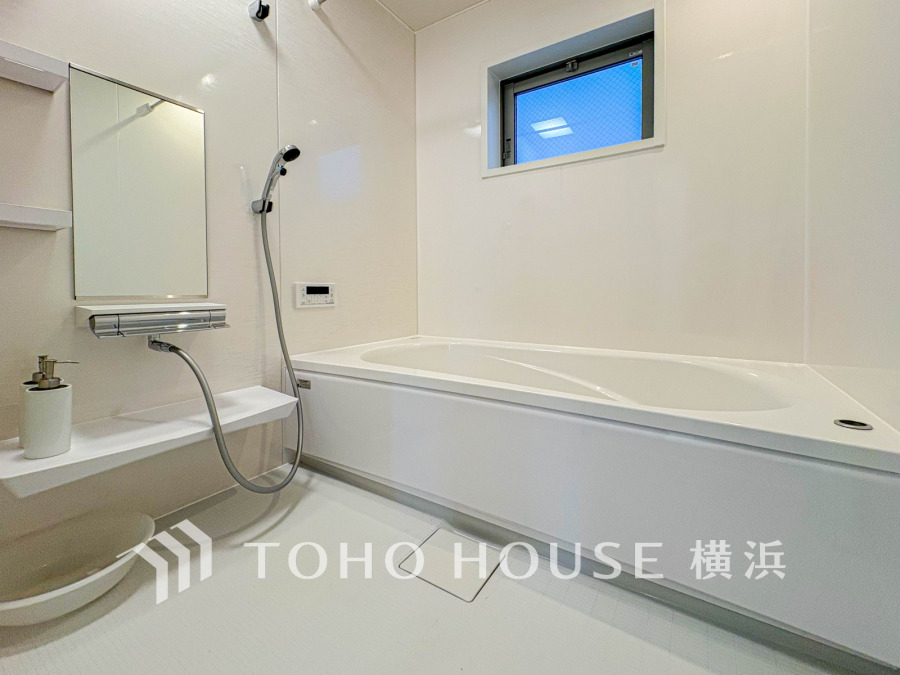 清潔感あふれる白基調のバスルーム。小窓から自然光が入り、快適な入浴時間を演出します。