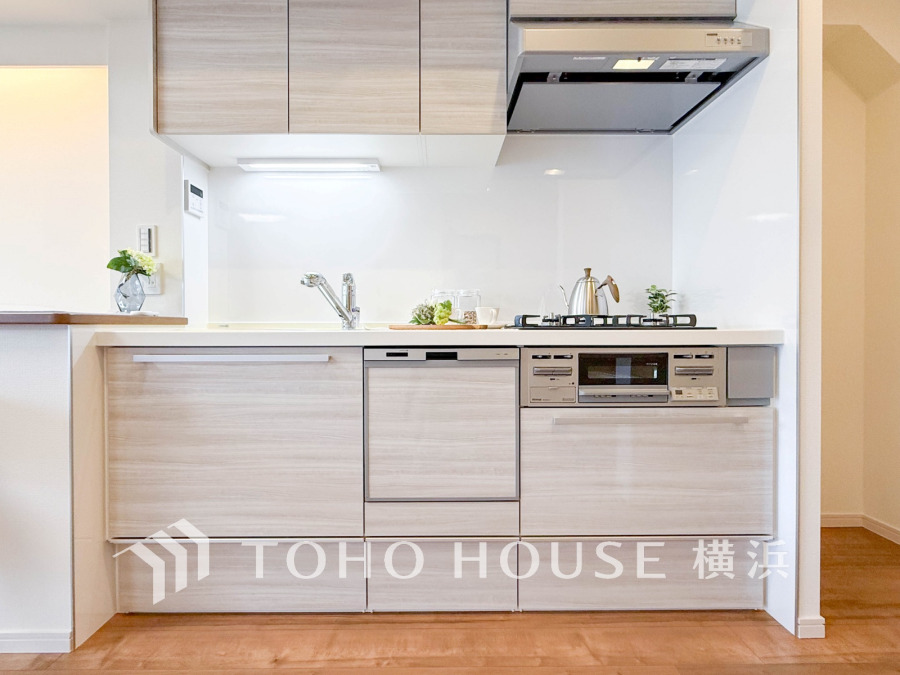 清潔感あふれるナチュラルカラーのシステムキッチン。収納豊富で使いやすく、料理が楽しくなる空間です。