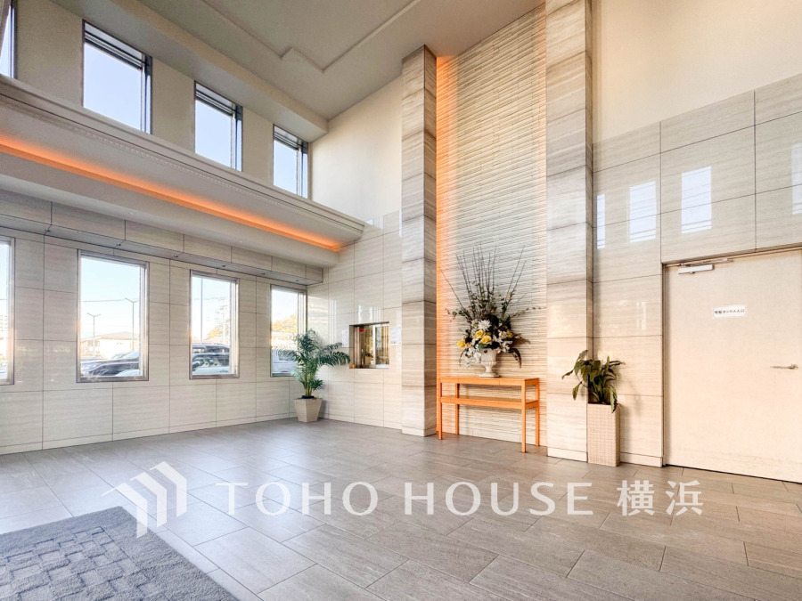 高い天井と大きな窓が開放感を演出する、明るく清潔感あふれるエントランスホールです。