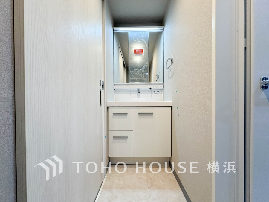 清潔感あふれる白を基調とした洗面スペース。コンパクトながら収納力も備え、使い勝手の良い設計です。