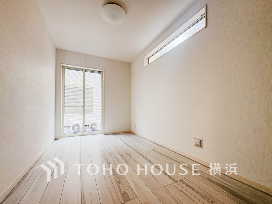 白を基調とした明るい洋室。大きな窓と高窓から自然光が入り、開放感ある快適な空間です。