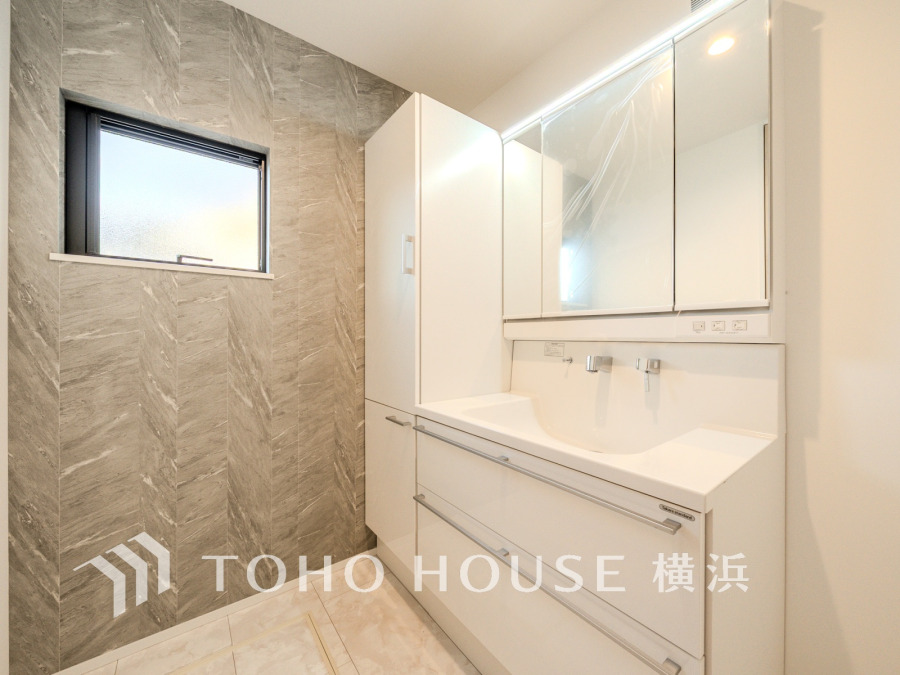 スタイリッシュなグレーの壁面がアクセントの洗面室。大容量収納と広い鏡で快適な毎日をサポートします。