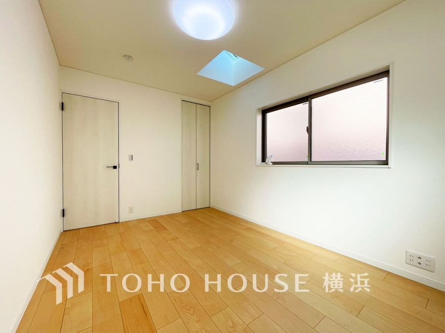 天窓から光が差し込む明るい室内。シンプルなデザインで多用途に活用できる快適な空間です。