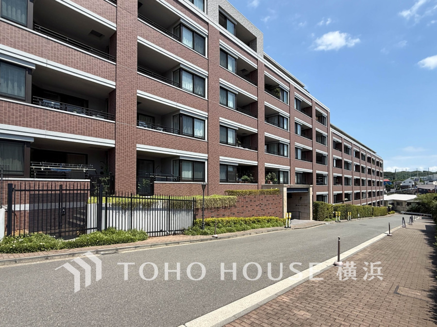 閑静な街並みに調和する落ち着いた外観。ふりそそぐ陽射しと青空を背景に美しさを醸す佇まい。
