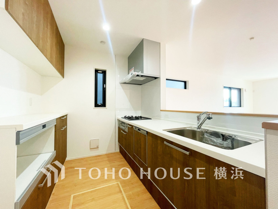 収納棚を背面に設置した統一感のあるキッチンスペースは美しく、機能性も良好です。