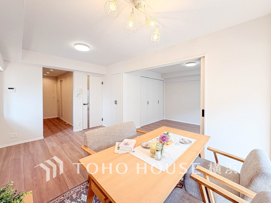 明るい自然光が差し込む、木目調フローリングと白壁のナチュラルなダイニング空間。収納も充実しています。